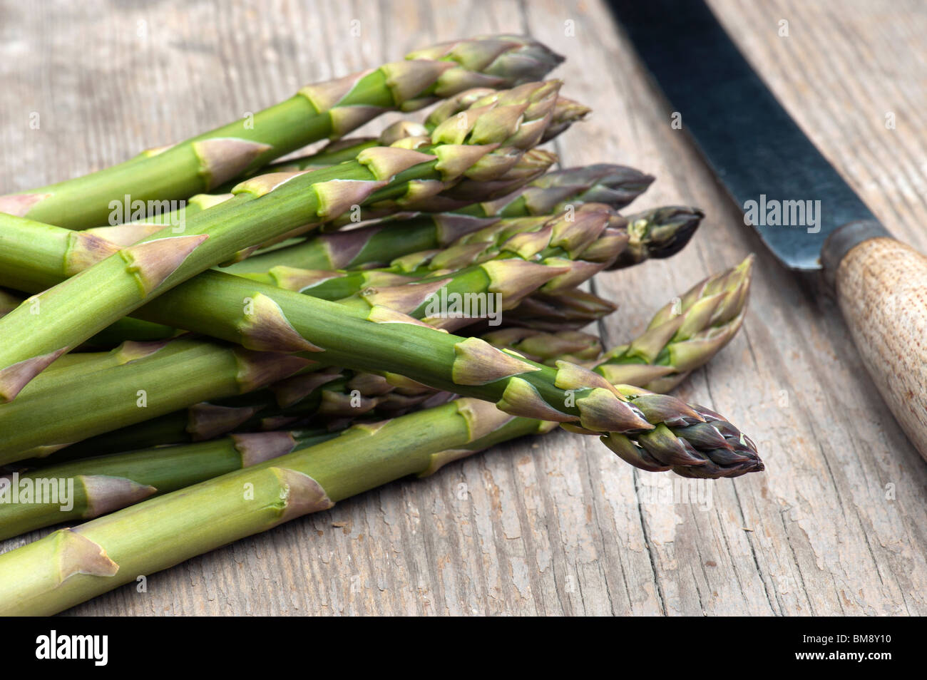 Asparagi freschi di cui su una cucina in legno Tabella Foto Stock
