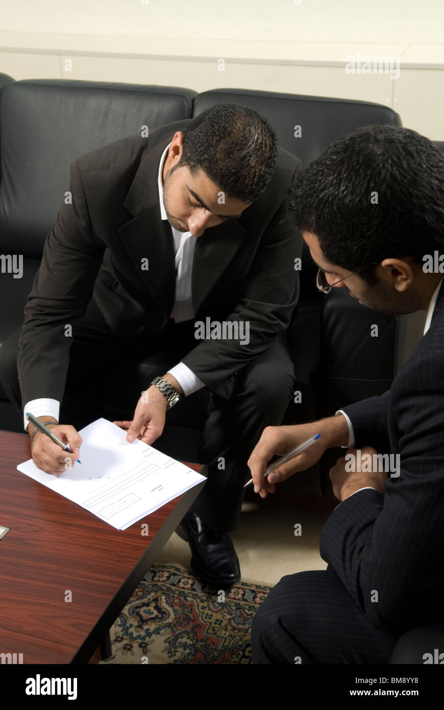 Due metà uomini orientale la firma dei contratti all'interno di office Beirut Libano Medio Oriente Foto Stock