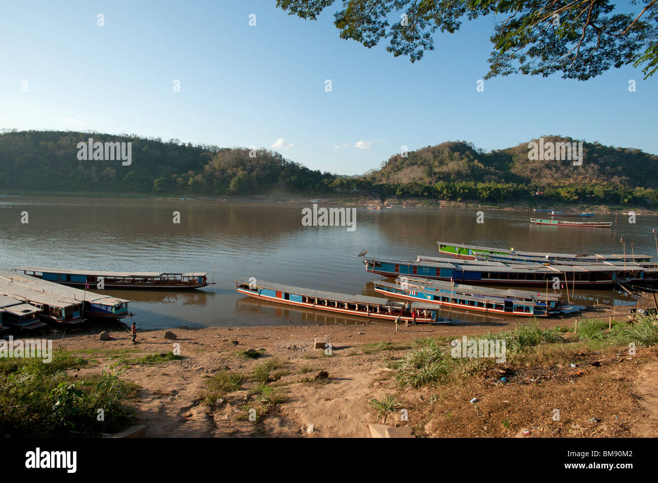 Lento in legno barche ormeggiate sulle rive del fiume Mekong a Luang Prabang, Laos Foto Stock