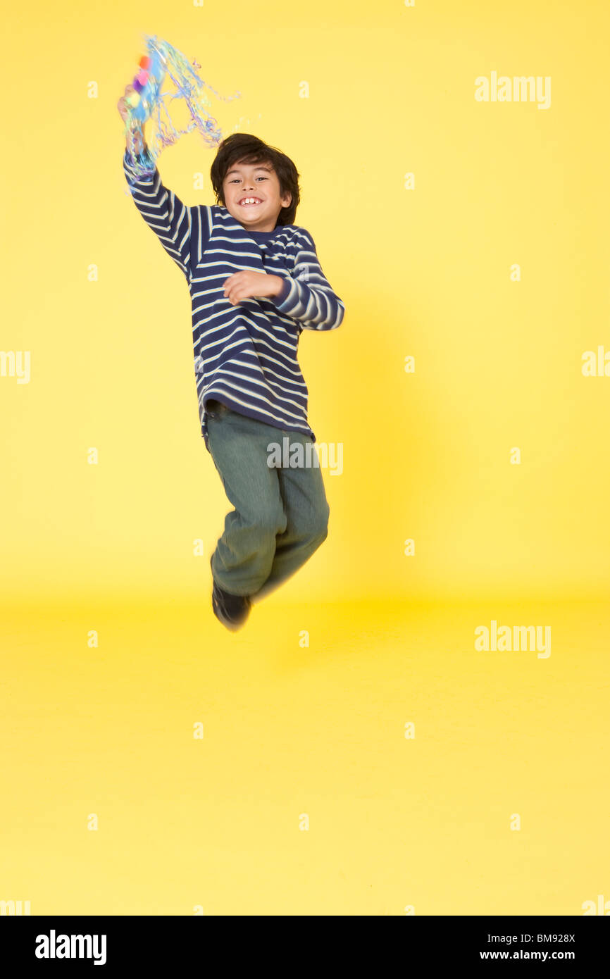 Ragazzo giocando con immaginario di fare credere che il fai da te in casa di artigianato tamburello strumento musicale Foto Stock