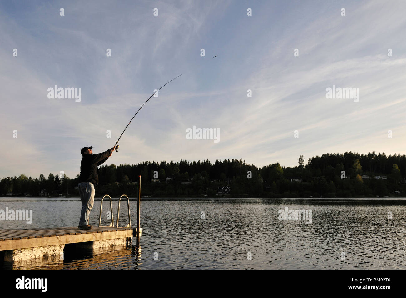Uomo di pesca sul lago vicino a Kosta a sera, Jonkopings Lan, Svezia Foto Stock