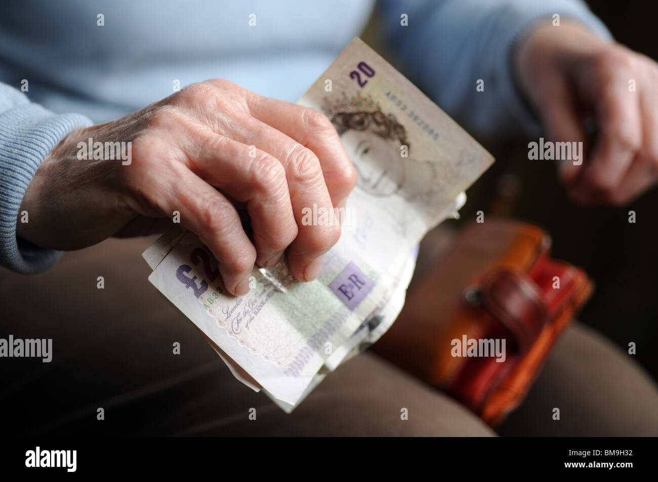 Vecchio di sesso femminile di età compresa tra i titolare di pensione o di rendita tenendo il denaro nelle sue mani artritiche Foto Stock