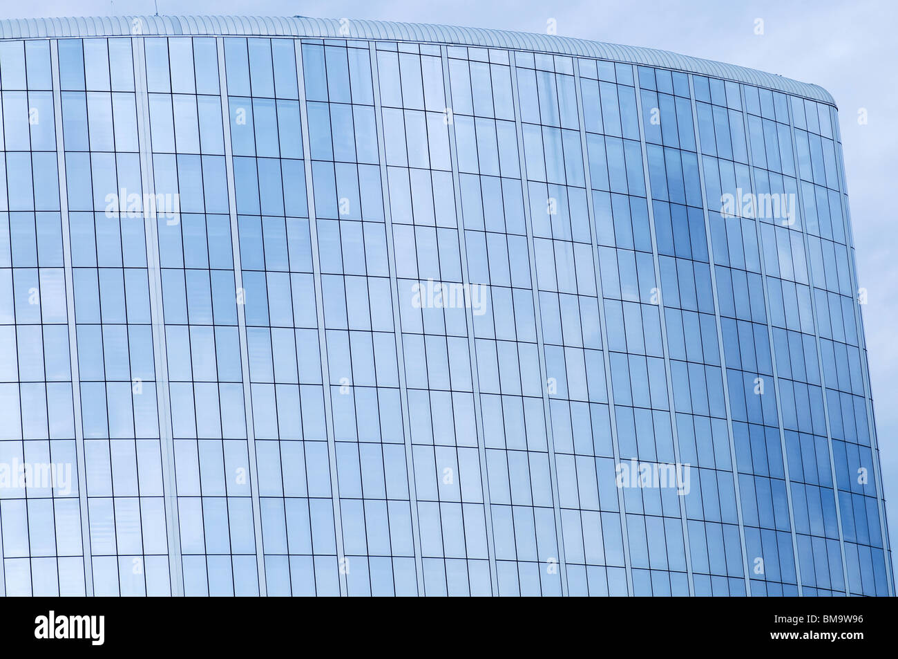 La parete di vetro del centro business e il riflesso del cielo Foto Stock