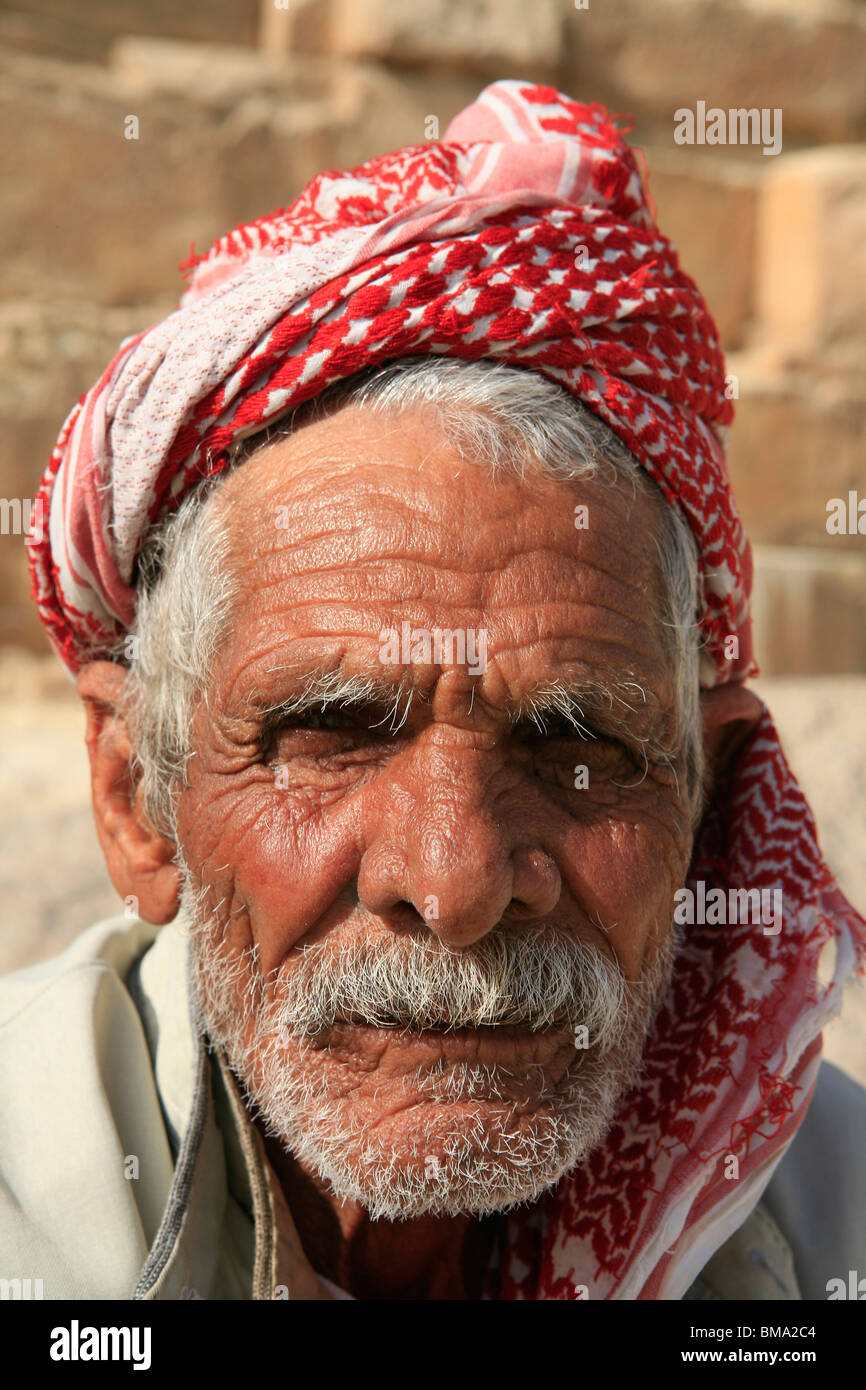 Close-up di un uomo egiziano in abito tradizionale di fronte alla piramide di Chephren a Giza, Egitto Foto Stock