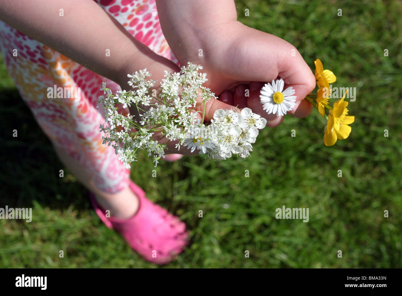 Giovane ragazza con un mazzo di fiori di campo Foto Stock