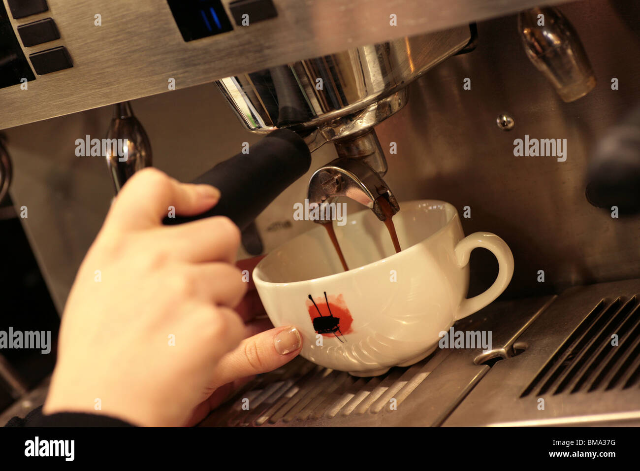 Una tazza di caffè versata da una macchina per il caffè Foto Stock