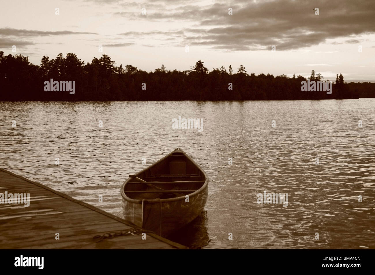 Il lago dei boschi, Ontario, Canada; barca in acqua vicino a un dock Foto Stock