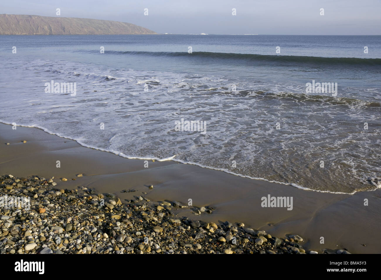 Piccole onde che si infrangono sulla serata di marea Foto Stock