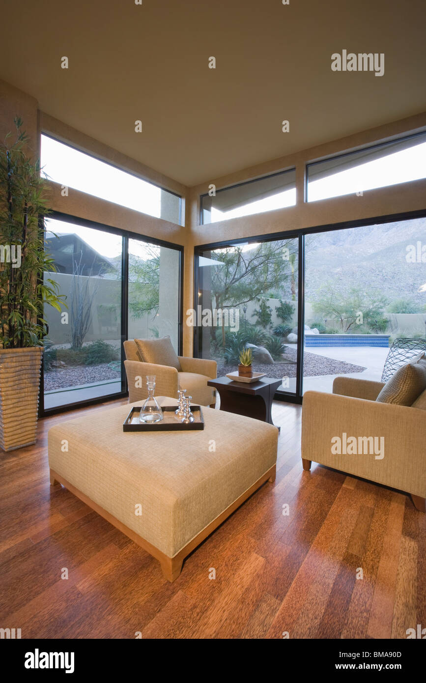 In modo neutro mobili imbottiti in angolo di camera con finestre da pavimento a soffitto Foto Stock