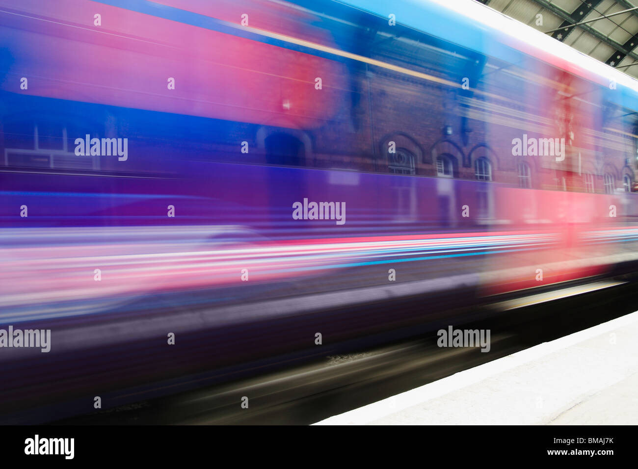 Velocizzando il treno che passa attraverso la stazione Foto Stock