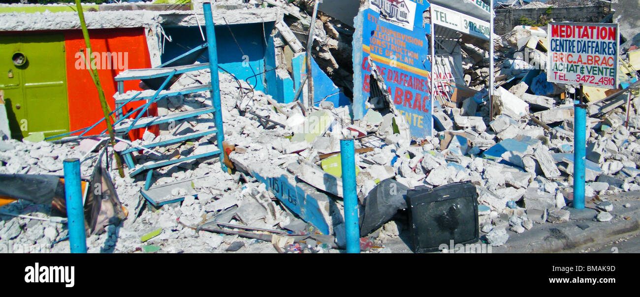 Un segno pubblicità la meditazione al fianco di edifici crollati a Port au Prince dopo il terremoto di Haiti Foto Stock