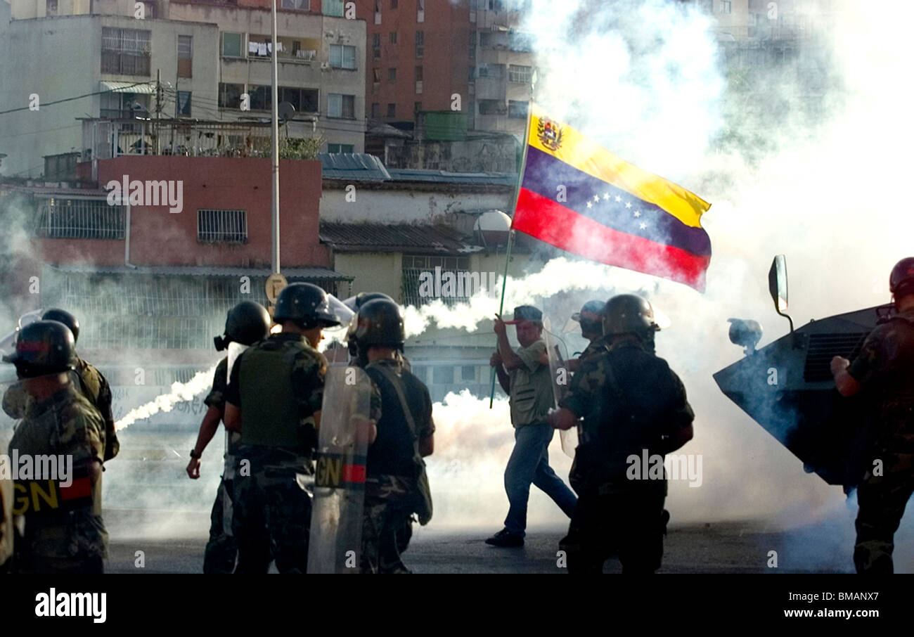 Un uomo si intreccia una bandiera venezuelana durante scontri a Caracas, Venezuela, Aug.14, 2002. Foto Stock