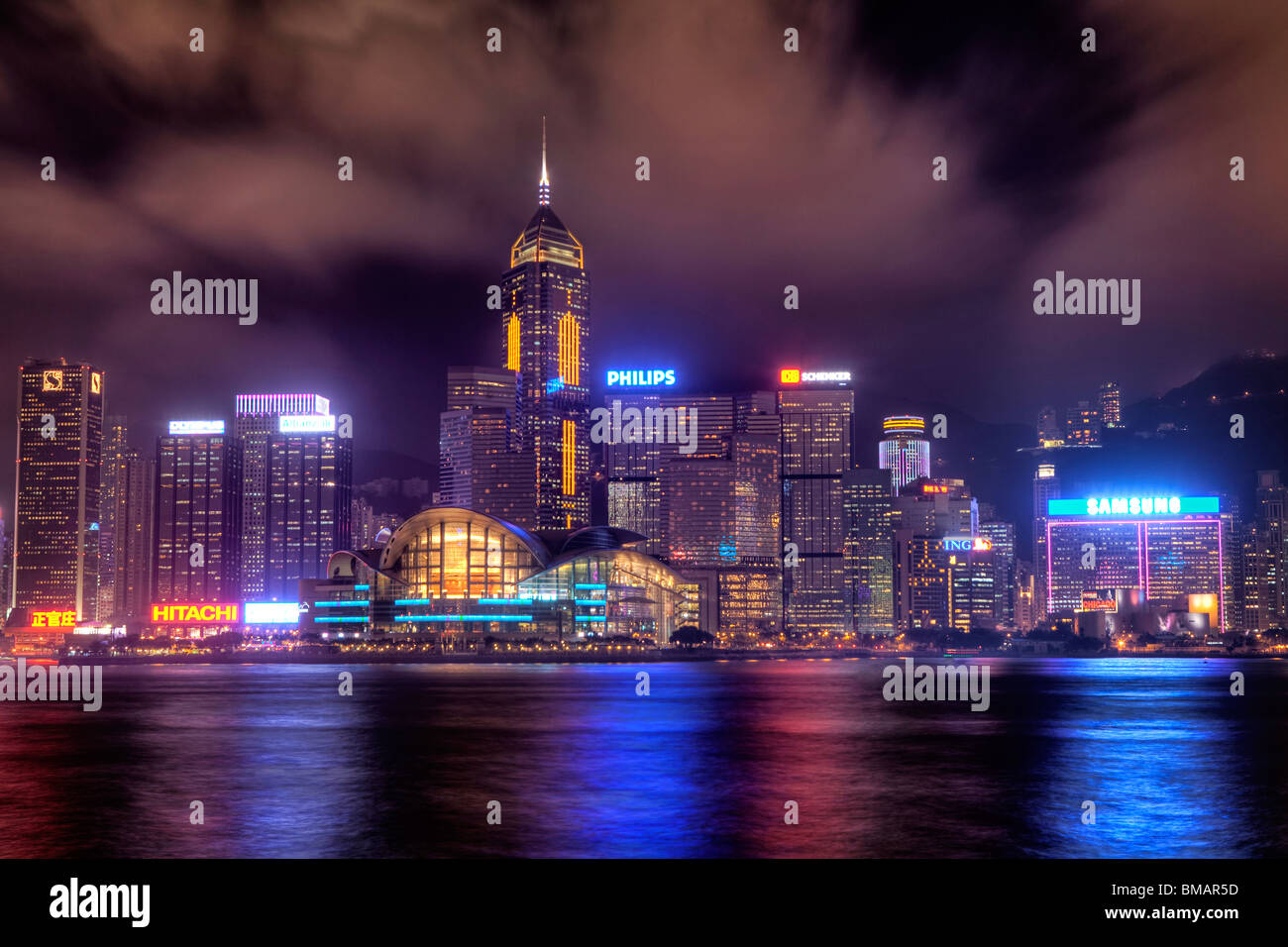 Edifici alti sull isola di Hong Kong city center come visto attraverso il porto da Tsim Sha Tsui in Kowloon Side di notte Foto Stock