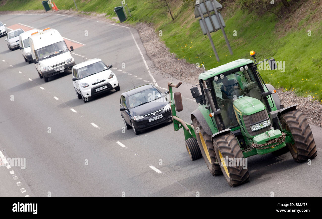 Coda di traffico dietro un veicolo lento trattrice agricola sulla A75 road UK Foto Stock