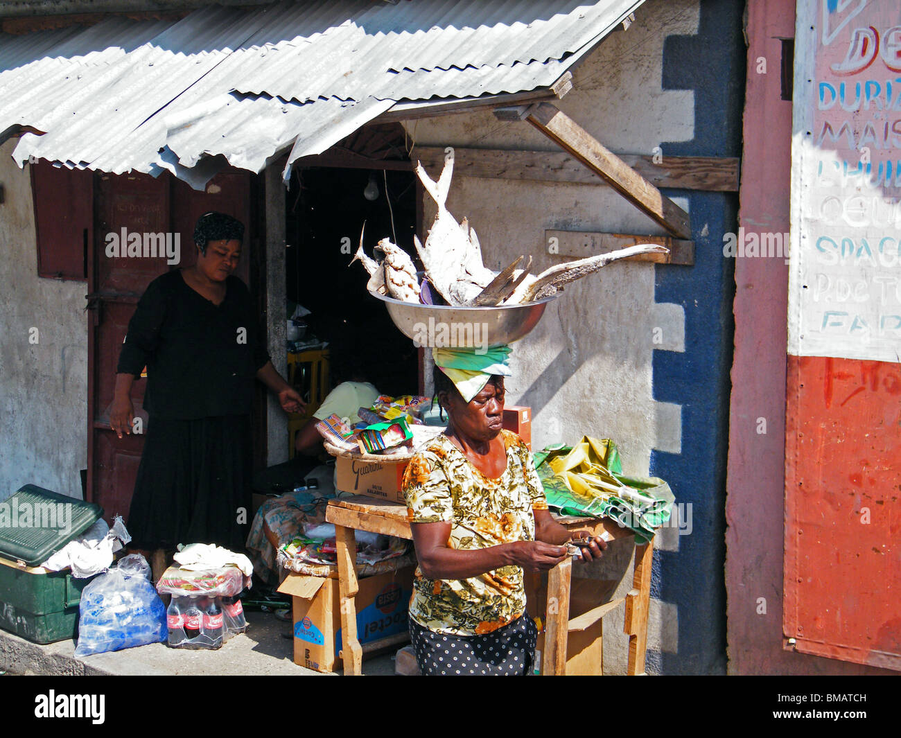 Una donna che porta una ciotola di pesce attraverso la Cité Soleil baraccopoli di Port au Prince dopo il terremoto di Haiti Foto Stock