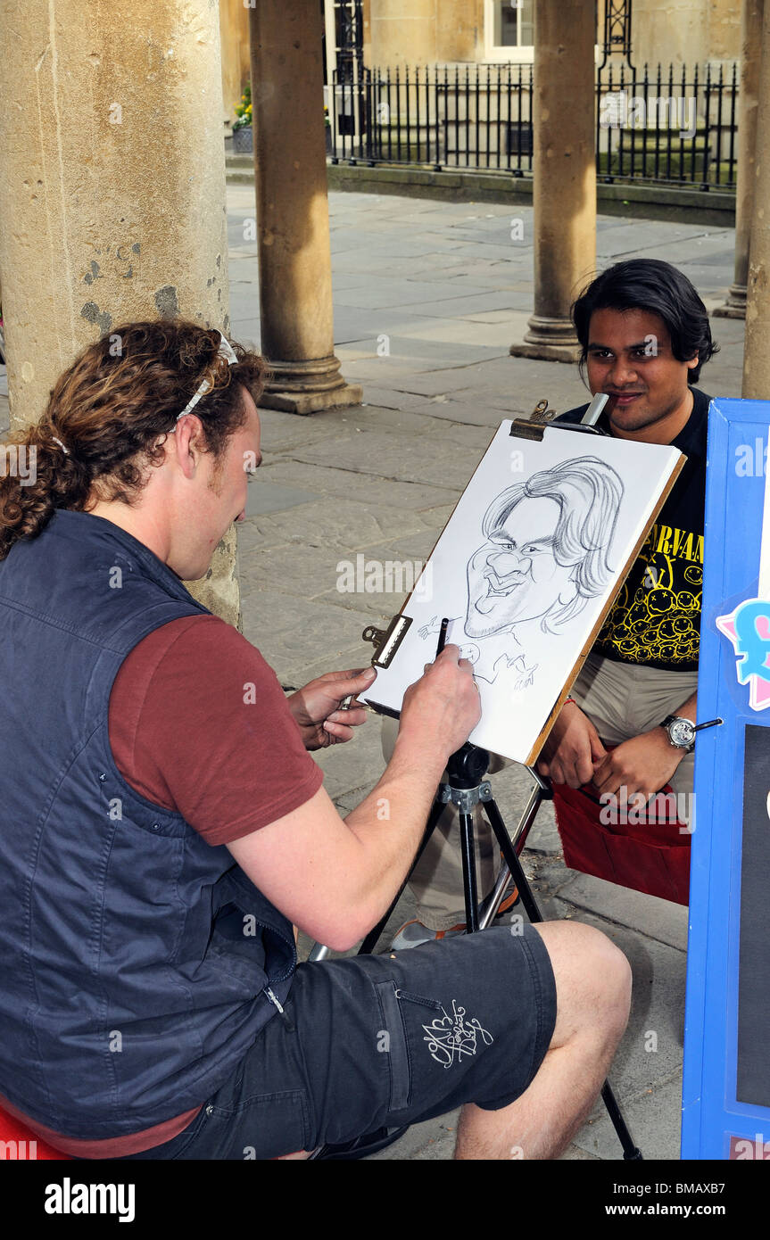 Un artista di strada in bagno, UK, il disegno di una caricatura del suo sitter. Foto Stock