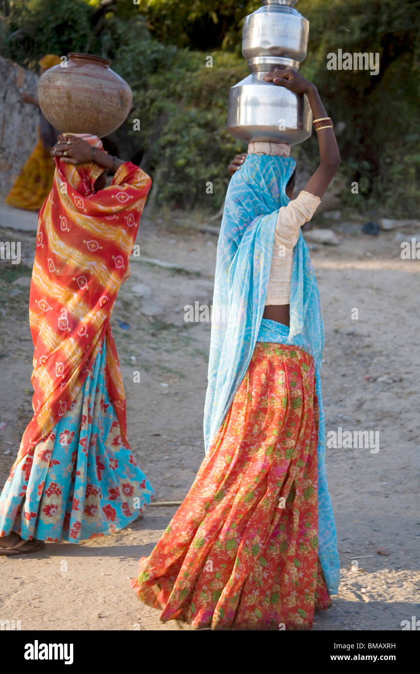 Le donne rurali portando vasi d'acqua sulla testa ; semi villaggio urbano Dilwara ; Udaipur ; Rajasthan ; India Foto Stock