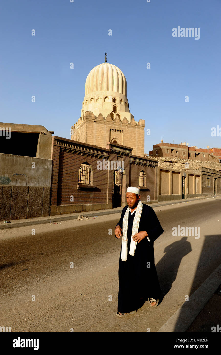 Uomo egiziano a piedi lungo una strada tranquilla nella parte meridionale di cimiteri, Cairo , Egitto Foto Stock