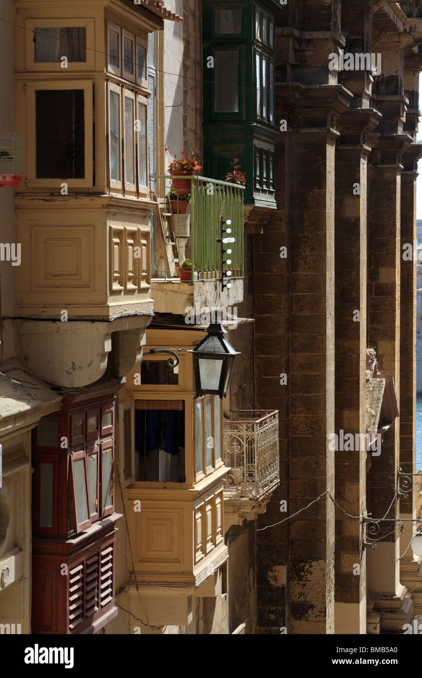 Una strada a La Valletta di Malta che mostra i disegni di balconi comune per l'isola Foto Stock