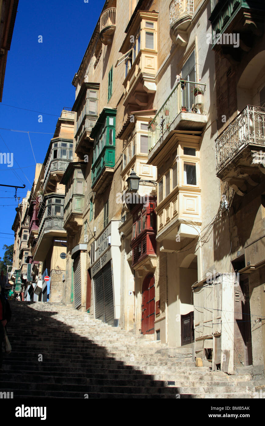 Una strada a La Valletta di Malta che mostra i disegni di balconi comune per l'isola Foto Stock