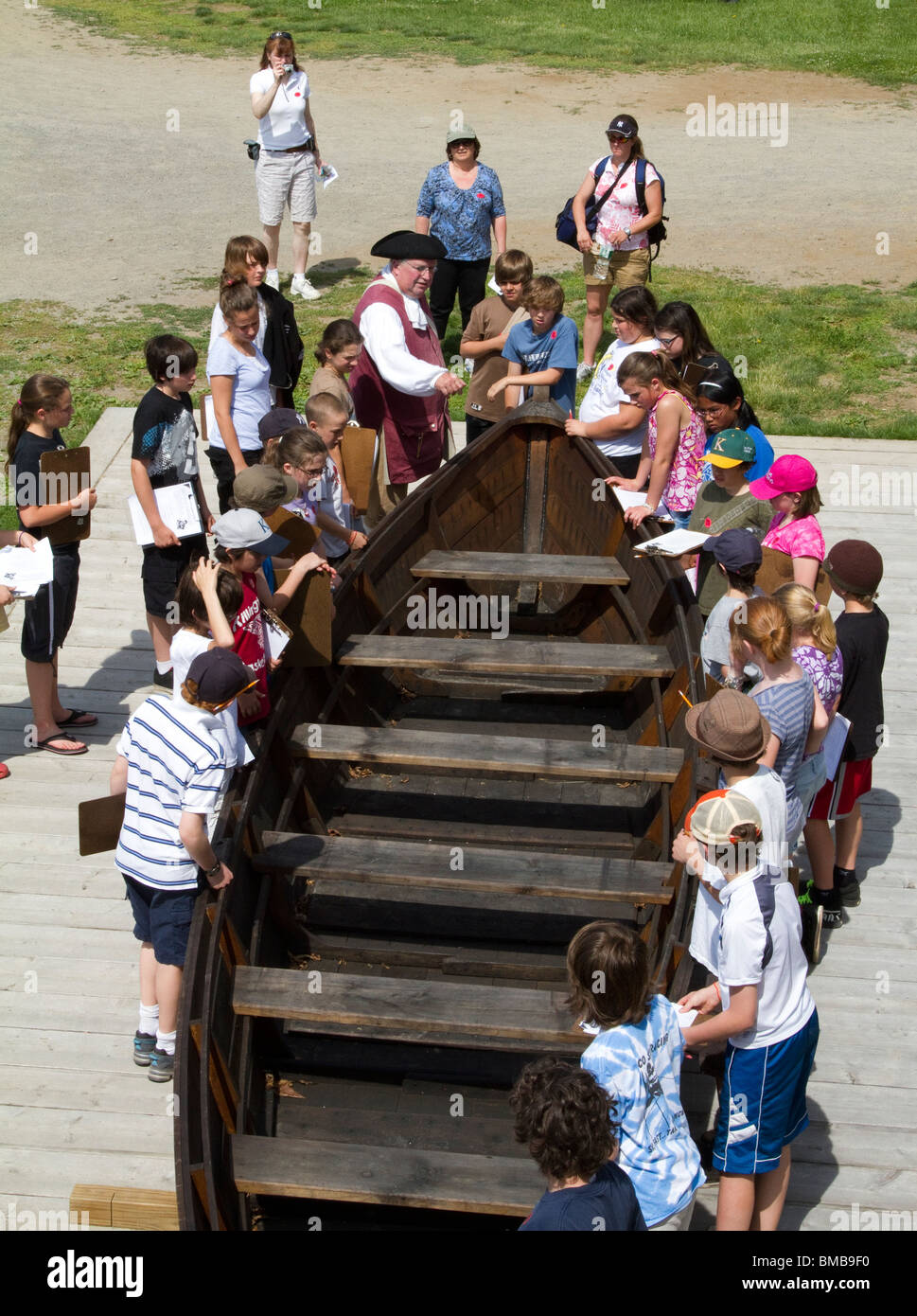 Un periodo vestito in costume a guida Fort Ticonderoga, New York con un gruppo di bambini. Insegnamento e lettura. Foto Stock