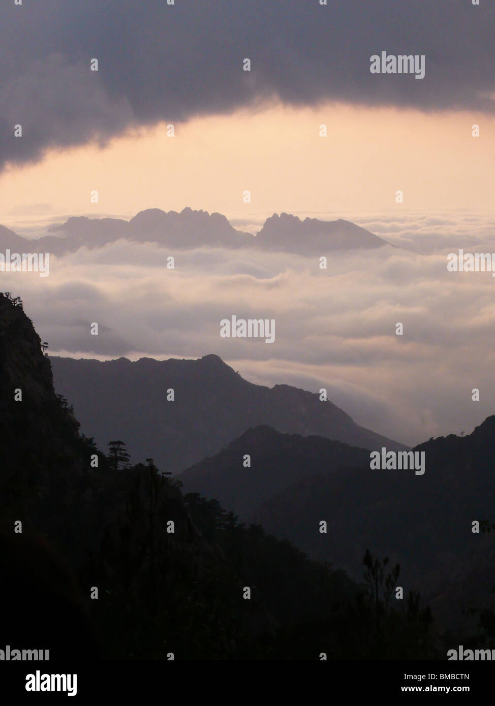 Il tramonto sopra le nuvole nelle montagne della Corsica Foto Stock