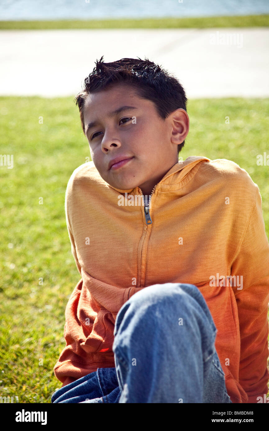 Multi culturale anno 10-12 anni ispanico American boy fuori contemplando la vita riflessivo di sognare guardando lontano vista frontale © Myrleen Pearson Foto Stock