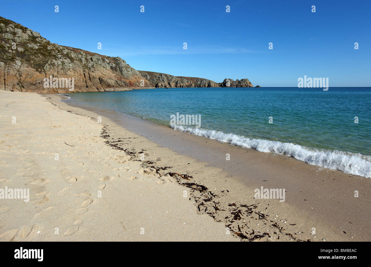 Porthcurno spiaggia sabbiosa di linea di terra e di roccia di Logan in Cornwall Regno Unito. Foto Stock