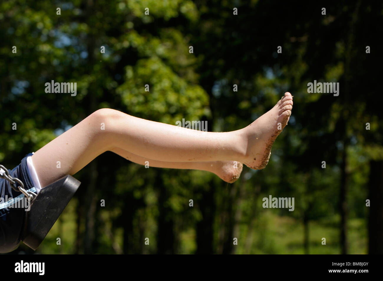 Foto di stock di 10 anno vecchio ragazzo basculante in un parco giochi swing. Foto Stock