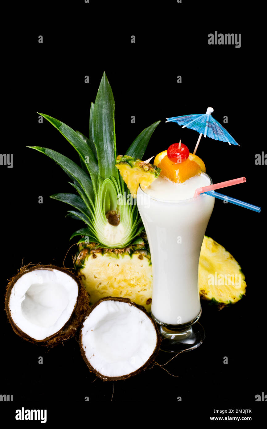 La Pina Colada su sfondo nero, guarnite con fette di ananas e noce di cocco. Foto Stock