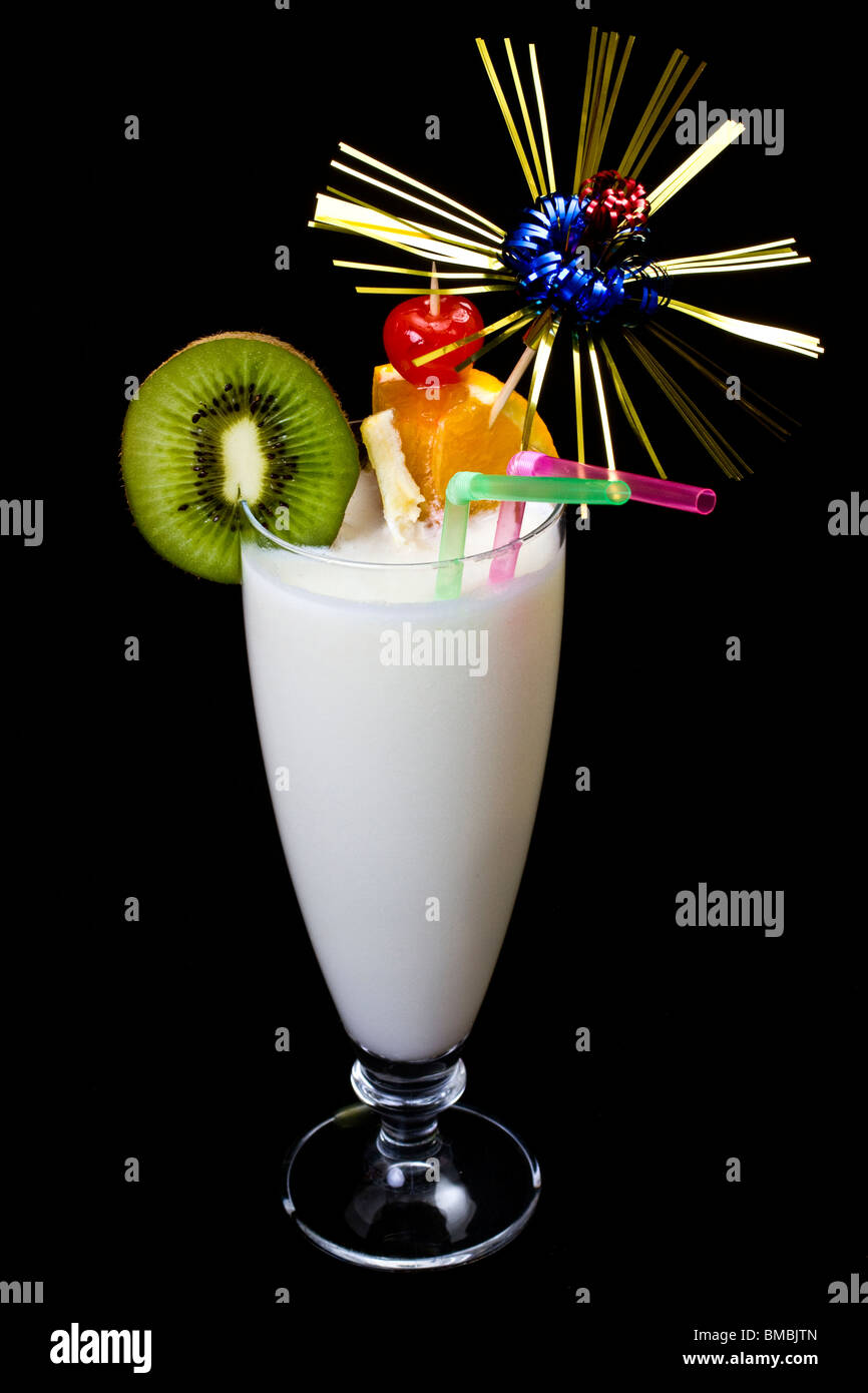 La Pina Colada su sfondo nero, guarnite con fette di kiwi e arancione. Foto Stock