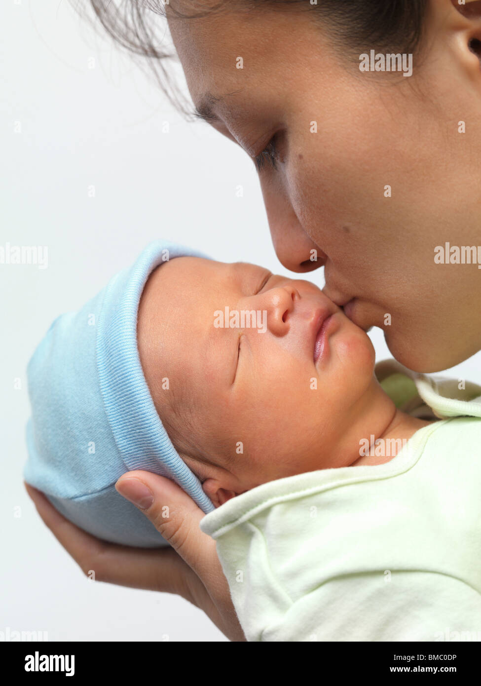 Madre baciando un sonno neonato bimbo sulla sua guancia Foto Stock