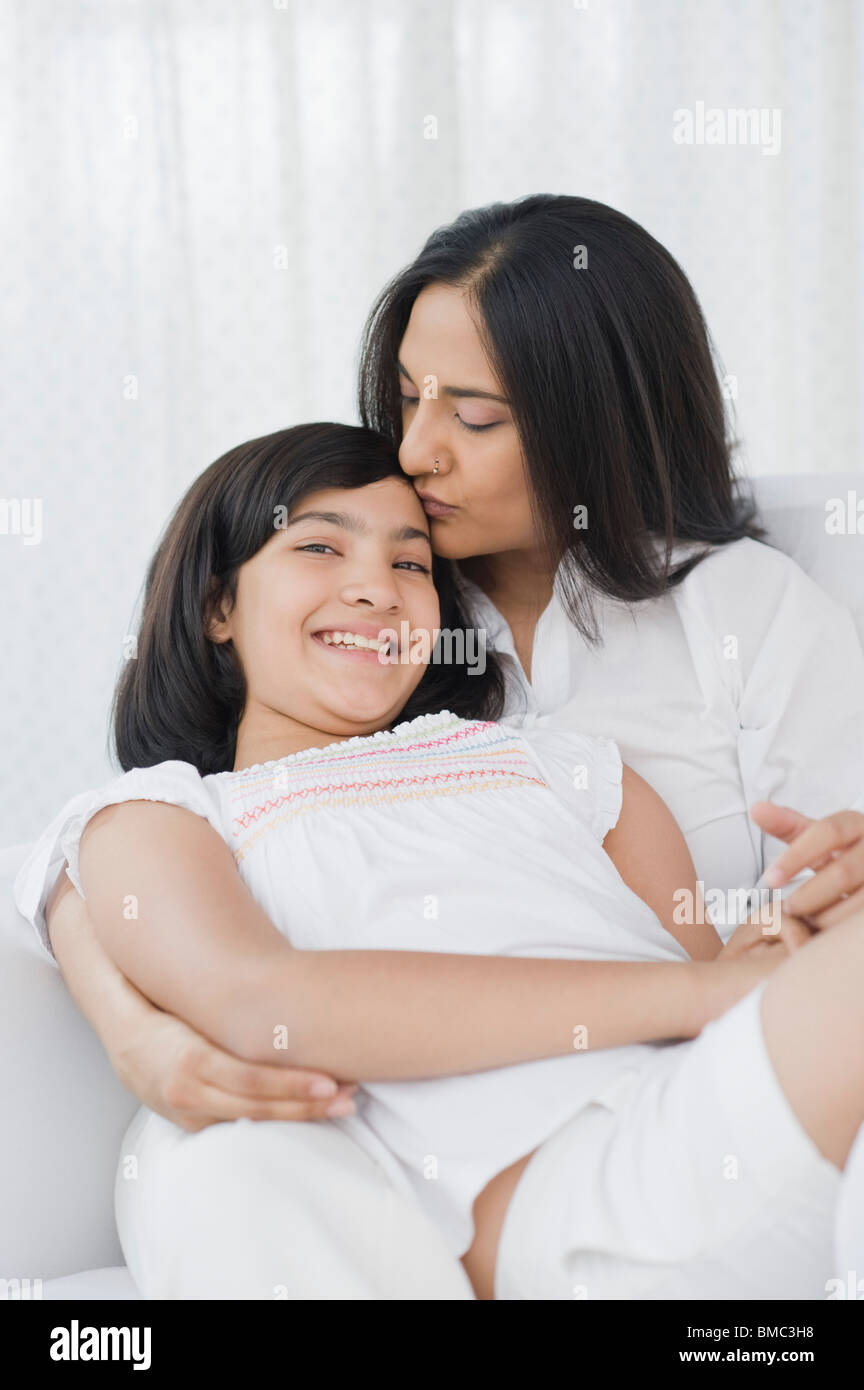 Close-up di una donna baciando la sua figlia sul fronte Foto Stock