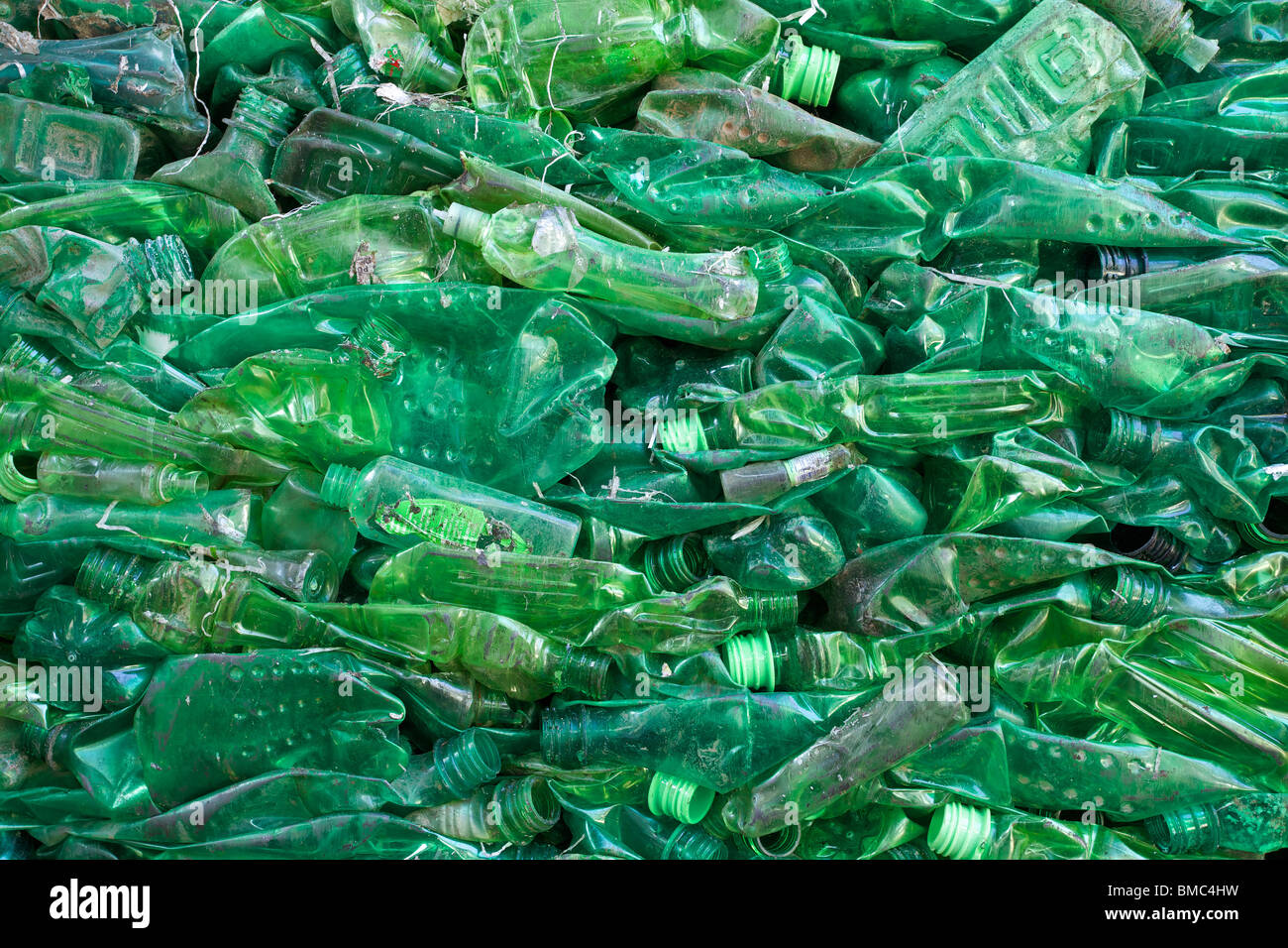 Schiacciato verde bottiglia di plastica di rifiuti a rifiuti di un impianto di riciclaggio Foto Stock