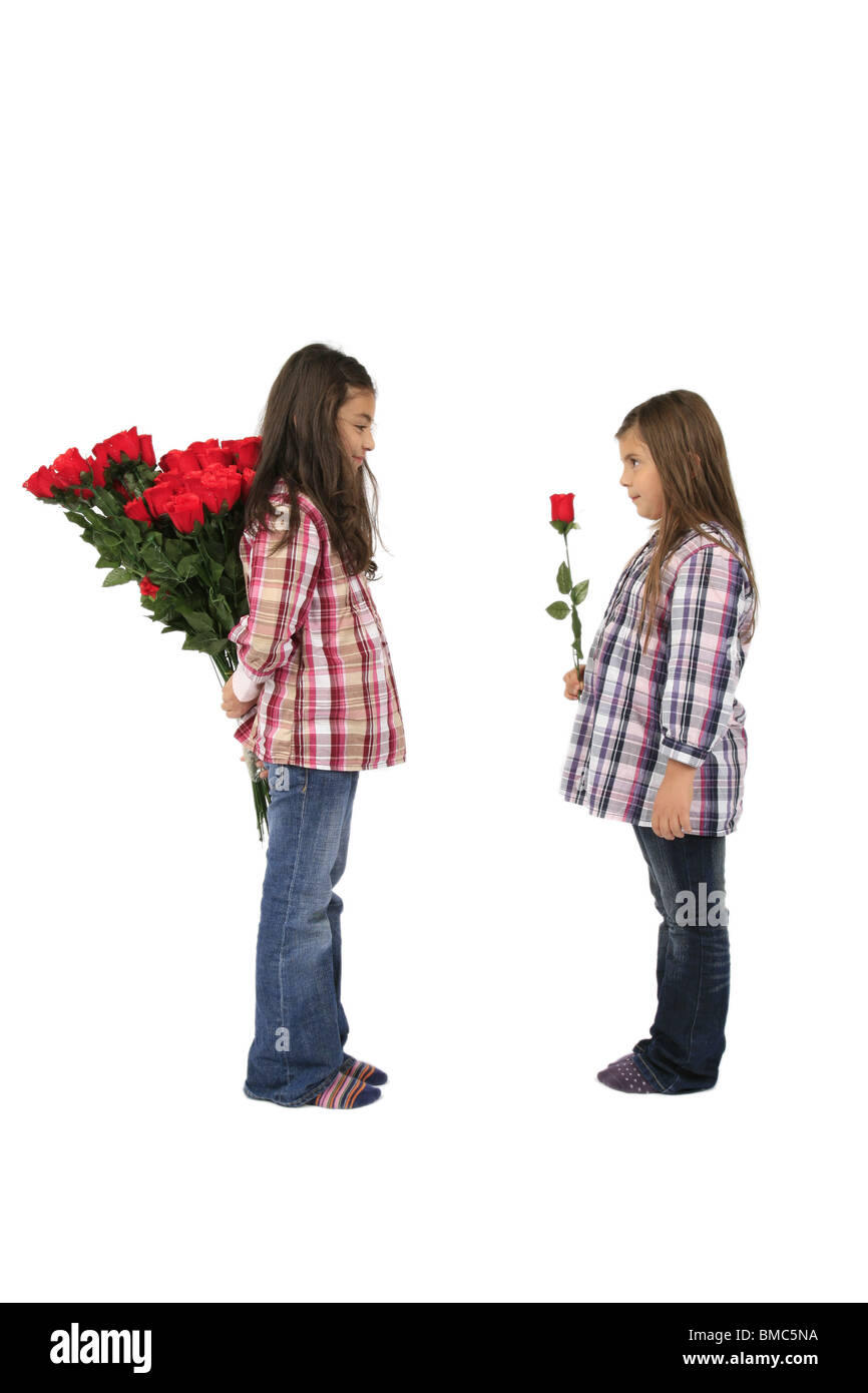 Due sorelle dando a ogni altro rose rosse Foto Stock