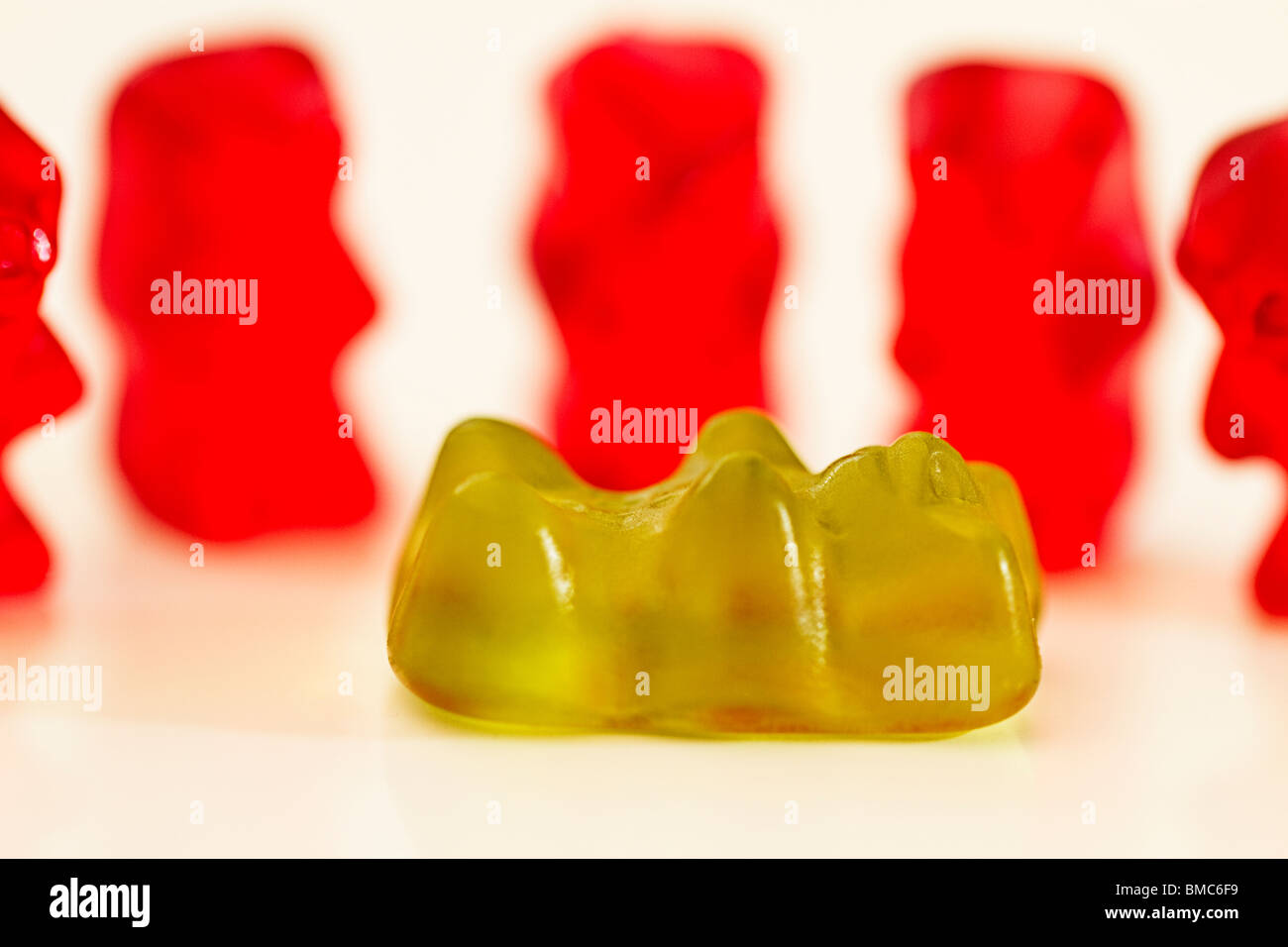 Uno jellybear verde si trova nella parte anteriore del gummibears rosso Foto Stock