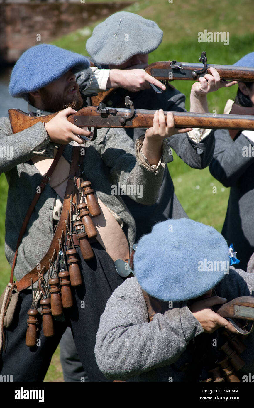 Scottish Covenanters maschio con Match-lock moschetto indossando la squallida abbigliamento scuro al Castello Caeverlock, Dumfries, Regno Unito Foto Stock