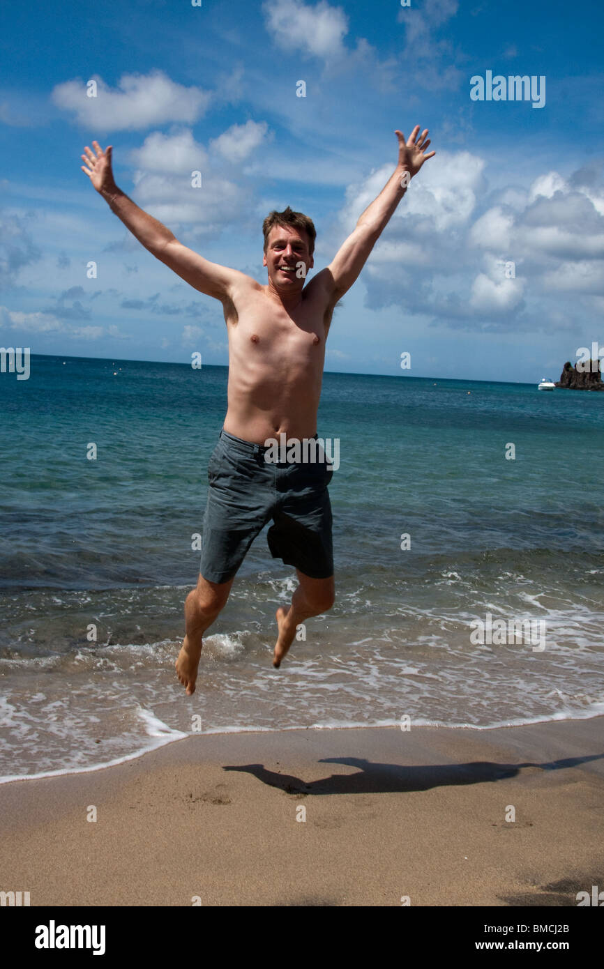 Un uomo vacanza al sole sulla spiaggia di sentirsi felice e libertà Foto Stock