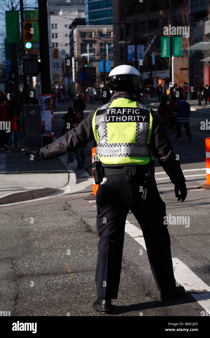 Officer in casco e hi-vis jacket gestiscono il traffico nel centro cittadino di Vancouver, British Columbia, Canada Foto Stock