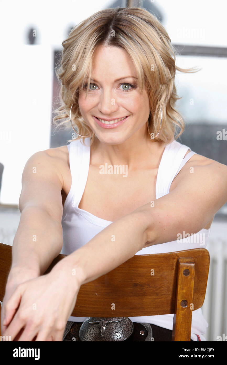 Donna seduta indietro nella sedia Foto Stock