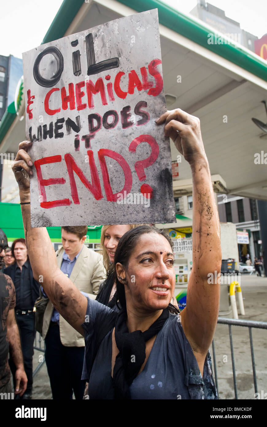 I manifestanti di versare liquidi che rappresentano l'olio su se stessi di fronte a BP gas station in New York Foto Stock