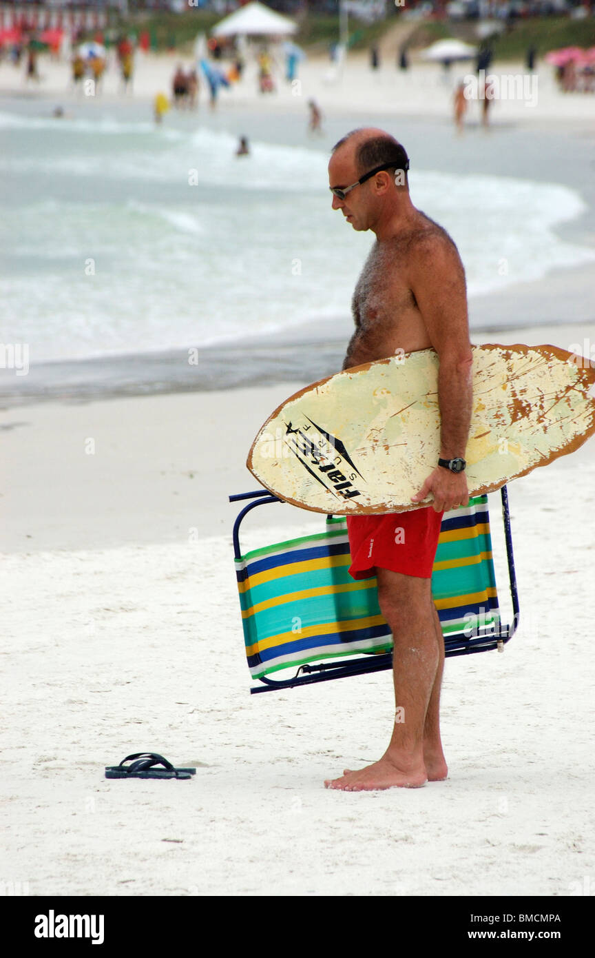 Surfer con il surf board e sedie da spiaggia in mano in spiagge di Cabo Frio,il Brasile,l America del sud Foto Stock