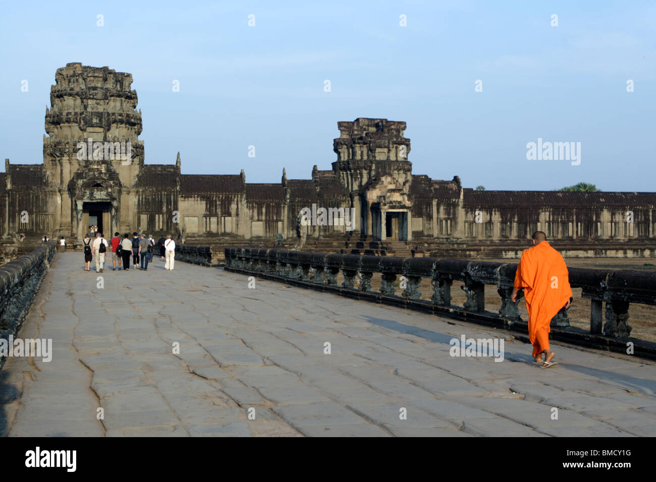 Un monaco camminando sul Naga Causeway verso il Gopura Occidentale, Angkor Wat, Cambogia. Foto Stock