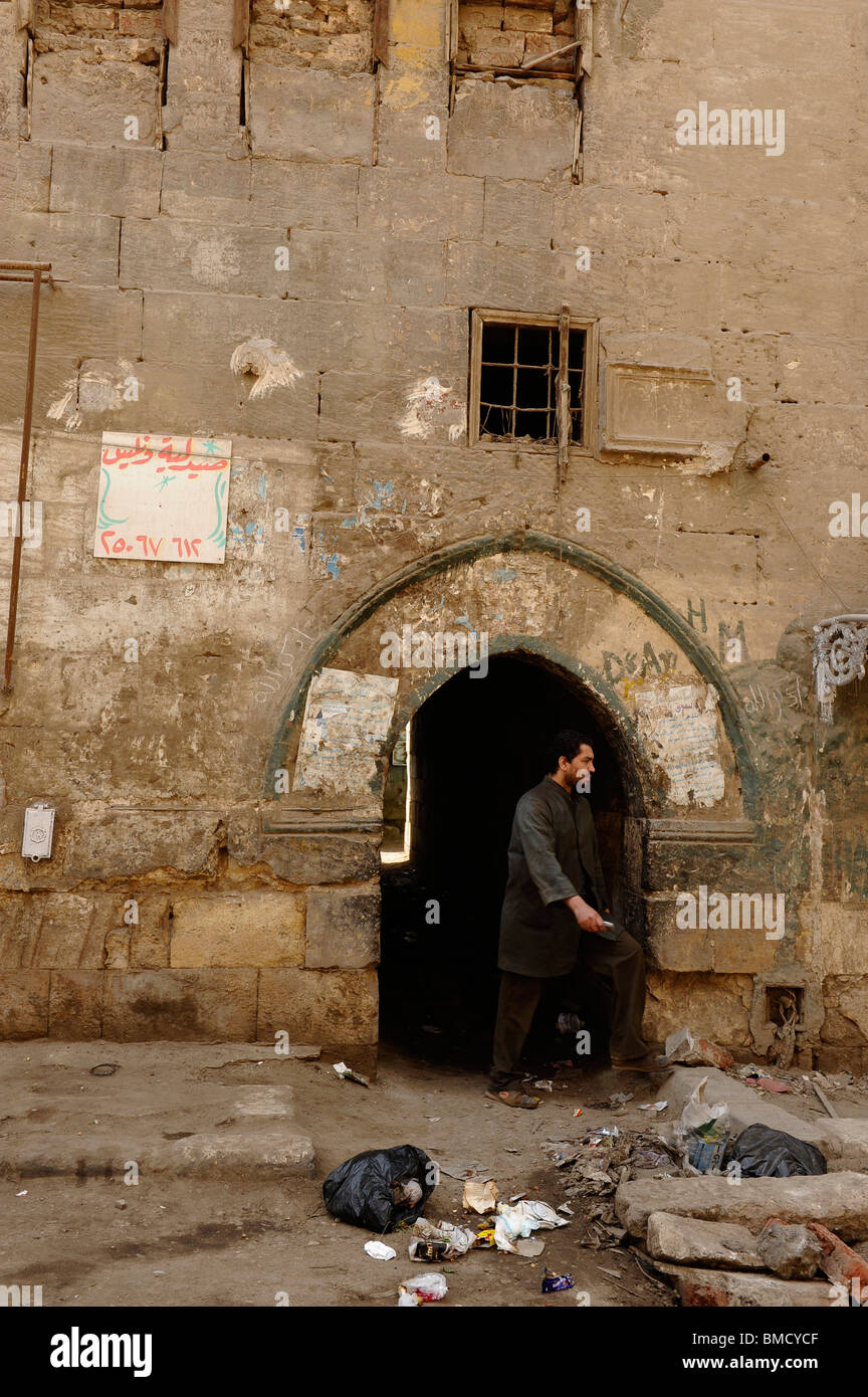 Uomo egiziano prendendo una scorciatoia attraverso archway nel vecchio edificio storico , Al Ghuriyya(al ghariya),de il Cairo islamico ,l'egitto Foto Stock