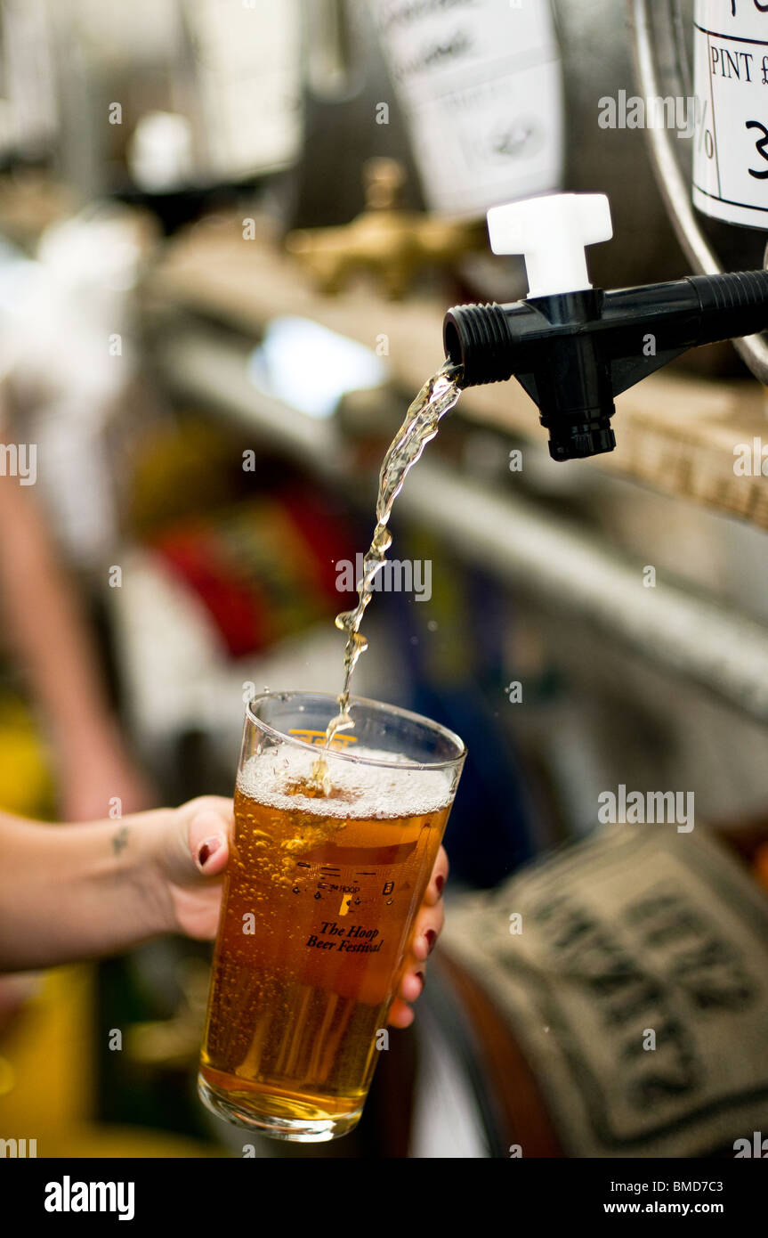 Una pinta di real ale che viene versato all'Hoop Pub festa della birra in magazzino in Essex. Foto Stock