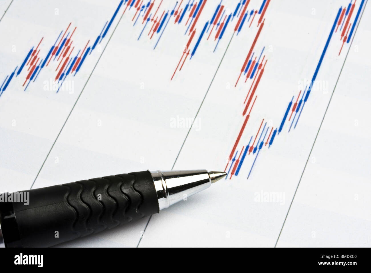 Una penna indica un grafico finanziario, simboleggiando l'analisi di mercato e la strategia di investimento. Foto Stock