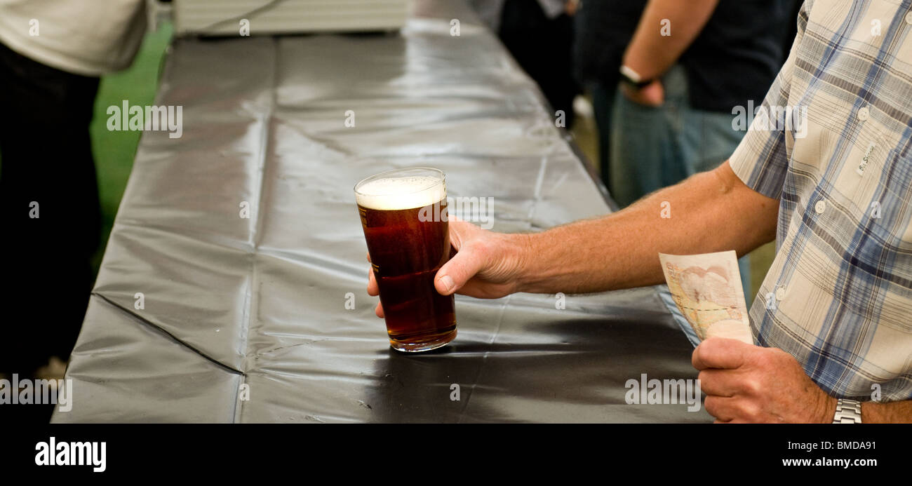 Festival della birra. Un cliente che acquista una pinta di birra reale all'Hoop Pub Beer Festival a stock nell'Essex. Foto Stock