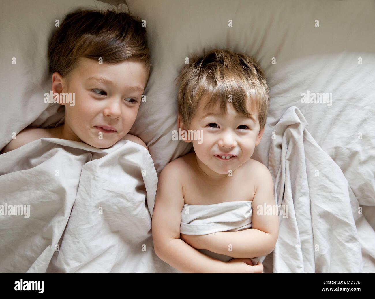 Fratelli che stabilisce nel letto Foto Stock