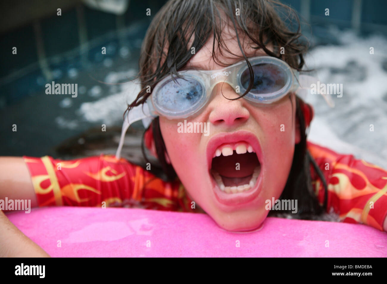 La ragazza di occhiali a giocare in piscina Foto Stock