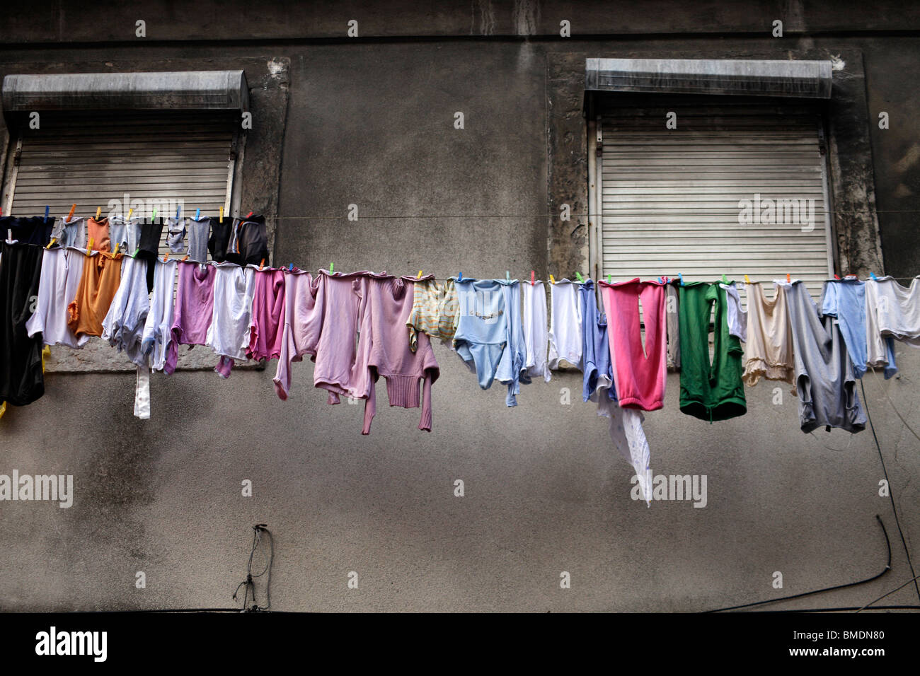 Abbigliamento colorato su una linea di abbigliamento di fronte ad una facciata di colore grigio a Lisbona, Portogallo, Europa Foto Stock
